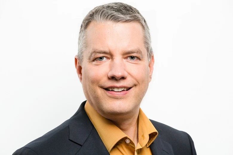 Portraitfoto von Moderator Thomas Lopau, der in die Kamera lächelt