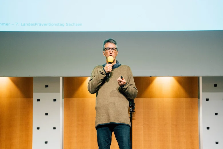 Mario Tormo Romero spricht auf der Bühne mit einem Mikrofon in der Hand